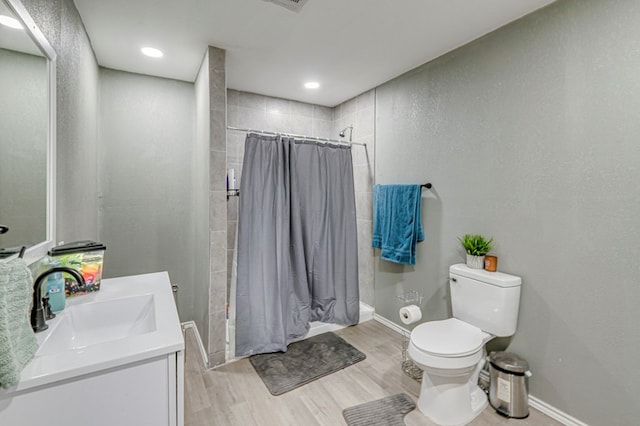 bathroom featuring vanity, toilet, curtained shower, and hardwood / wood-style floors