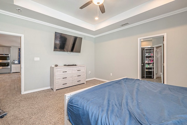 bedroom featuring ceiling fan, carpet flooring, and a raised ceiling