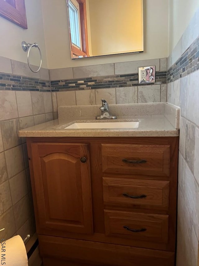 bathroom featuring vanity and tile walls