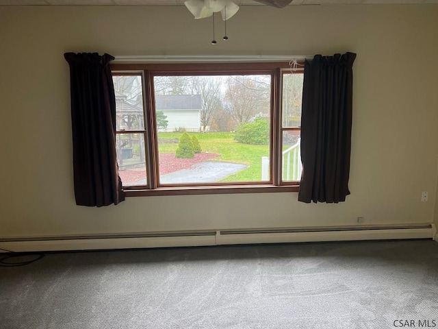 carpeted spare room featuring a baseboard heating unit