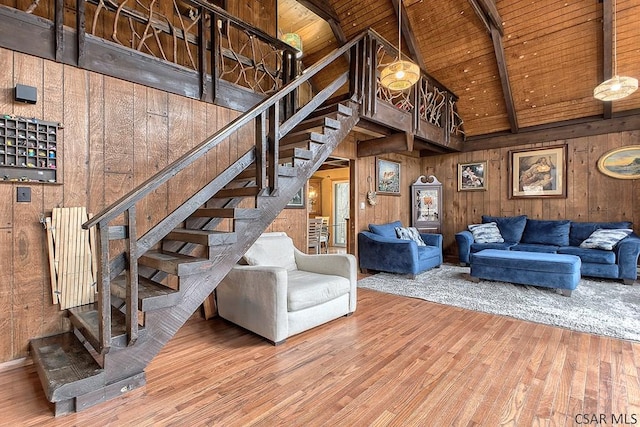 living area with wooden ceiling, wooden walls, beamed ceiling, and high vaulted ceiling