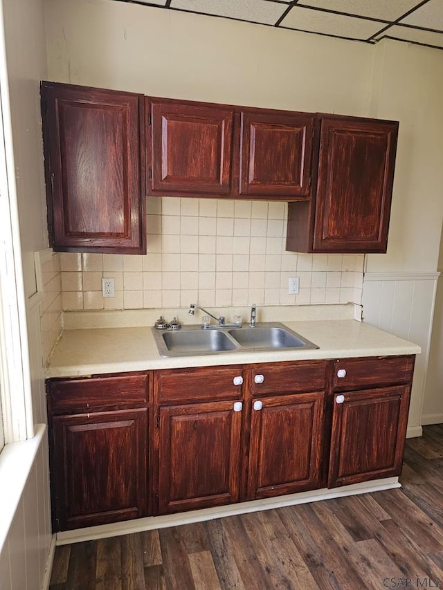 kitchen with reddish brown cabinets, dark wood-style floors, light countertops, and a sink