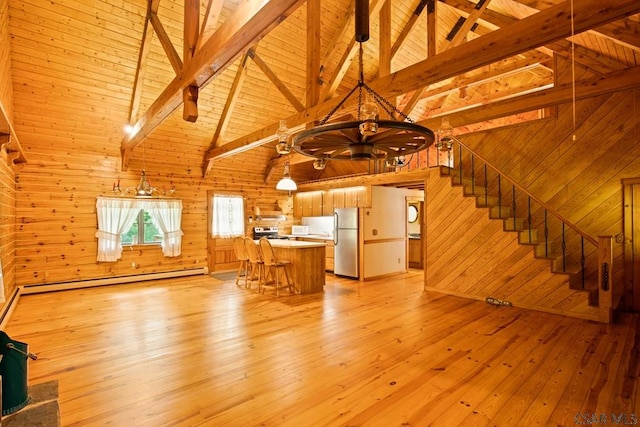 2484 Berlin Plank Rd, Berlin, PA 15530 - unfurnished living room featuring a baseboard radiator, a chandelier, wooden walls, light wood-style flooring, and stairs