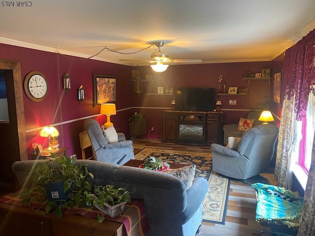 living area with ceiling fan, crown molding, and wood finished floors