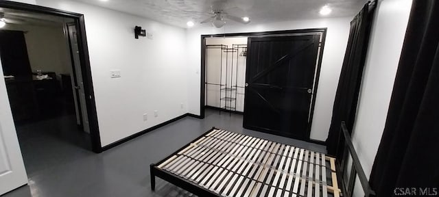 bedroom with finished concrete floors and baseboards