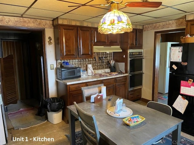 1804 Somerset Ave, Windber, PA 15963 - kitchen featuring black appliances, under cabinet range hood, light countertops, a drop ceiling, and backsplash