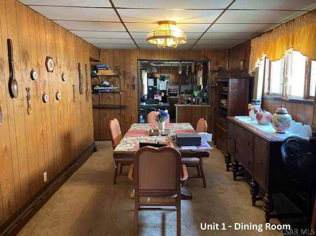 1804 Somerset Ave, Windber, PA 15963 - dining space with light colored carpet, wood walls, a drop ceiling, and a chandelier