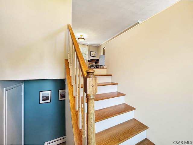 staircase featuring a baseboard heating unit