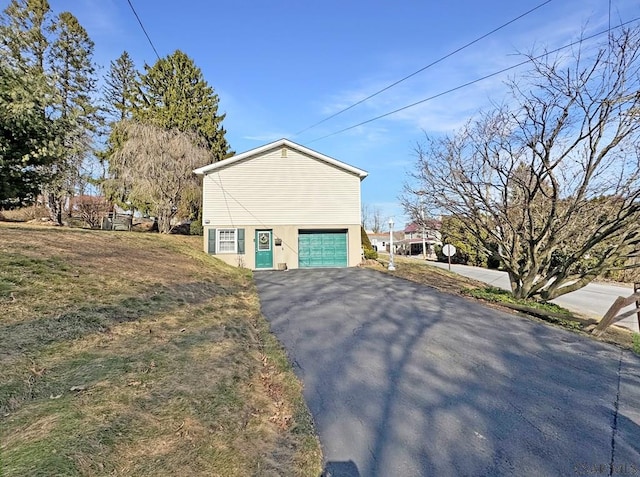 view of home's exterior with aphalt driveway, a garage, and stucco siding