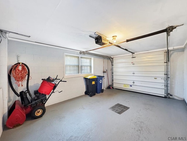 garage with concrete block wall and a garage door opener