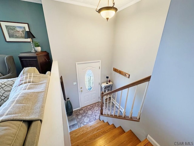 entrance foyer featuring stairs, crown molding, and baseboards