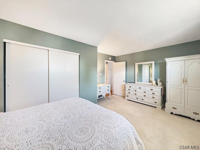 bedroom featuring light colored carpet and a textured ceiling