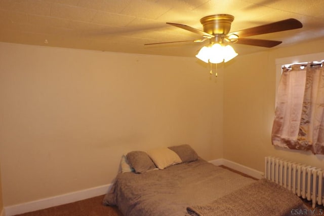 carpeted bedroom with ceiling fan and radiator