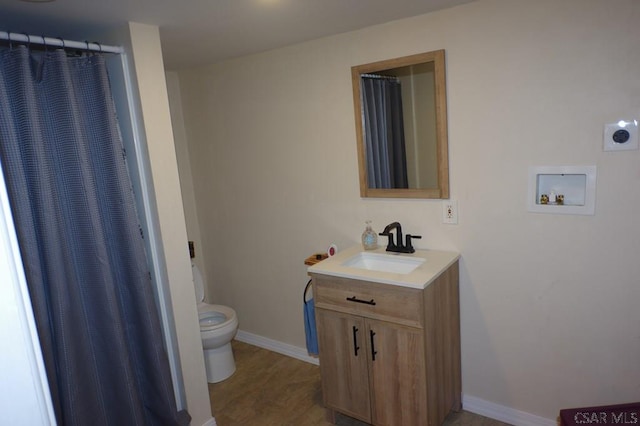 bathroom with vanity, wood-type flooring, and toilet