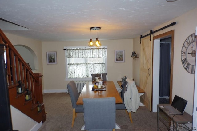 dining space featuring a barn door, radiator, a textured ceiling, and carpet flooring