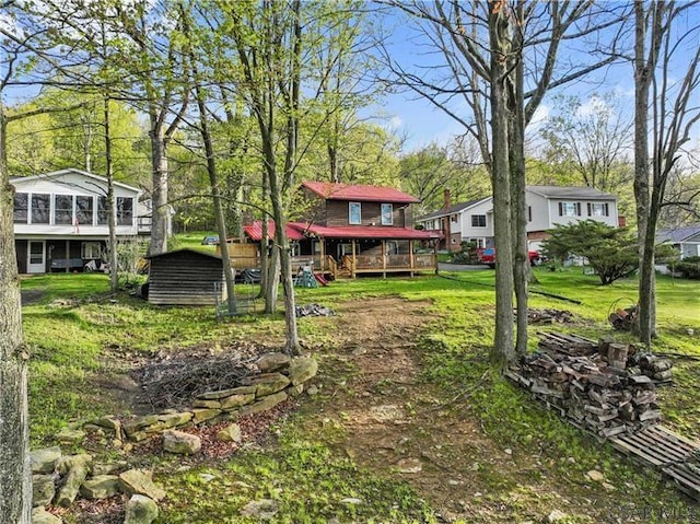 1036 Causeway Dr, Friedens, PA 15541 - view of green lawn featuring a deck, an outdoor structure, a storage unit, and a sunroom