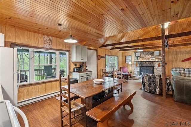 1036 Causeway Dr, Friedens, PA 15541 - dining area featuring wood walls, a baseboard heating unit, wood finished floors, wood ceiling, and a stone fireplace