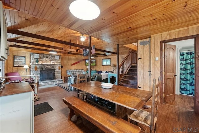 1036 Causeway Dr, Friedens, PA 15541 - dining space with wooden walls, wood finished floors, wooden ceiling, a stone fireplace, and stairs