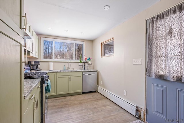 kitchen featuring green cabinetry, light wood-style flooring, appliances with stainless steel finishes, a baseboard heating unit, and a sink