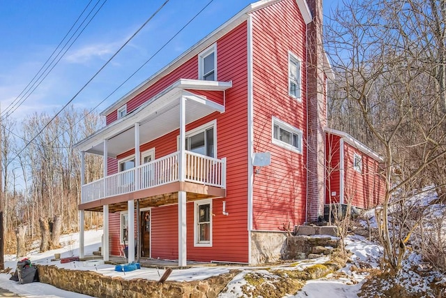 snow covered property featuring a balcony