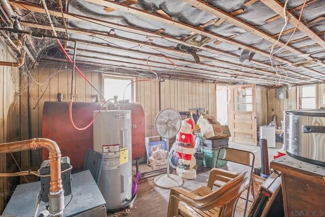 below grade area with electric water heater and wood finished floors