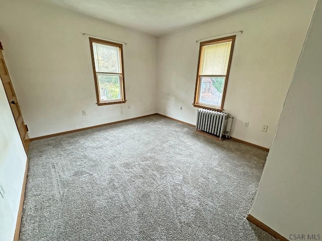 empty room with radiator and carpet flooring