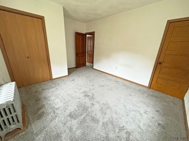 unfurnished bedroom with light carpet and a closet