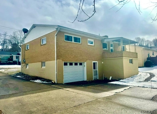 back of property featuring a garage and brick siding