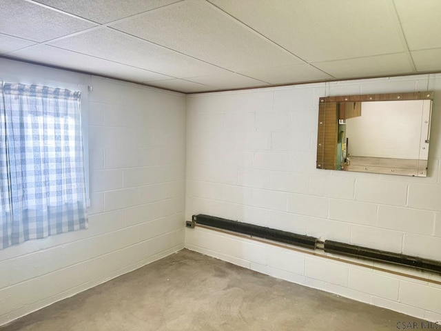 interior space with concrete block wall and a drop ceiling