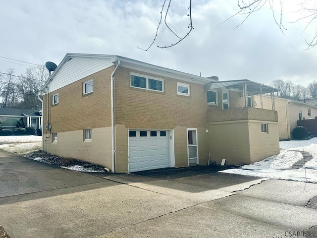 back of property featuring a garage and brick siding