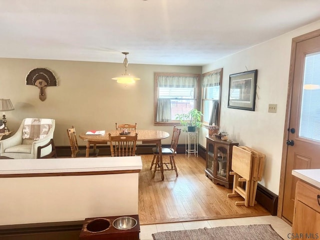 dining space featuring light tile patterned floors, a baseboard heating unit, and baseboards