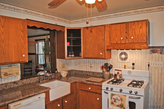 kitchen with ceiling fan, white appliances, sink, and dark stone countertops