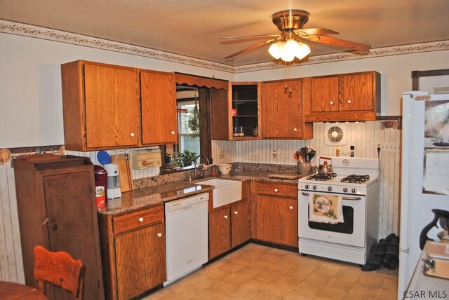 kitchen with ceiling fan, sink, dark stone countertops, and white appliances