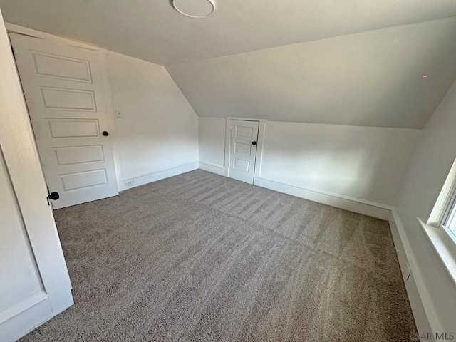 additional living space with vaulted ceiling and carpet