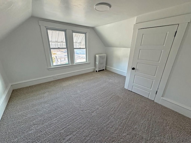 bonus room with lofted ceiling, radiator, and carpet flooring