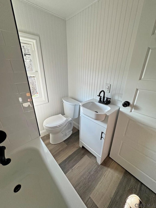 bathroom with vanity, hardwood / wood-style floors, a bath, and toilet