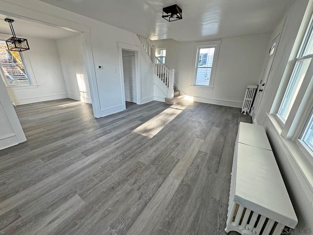 unfurnished living room with radiator heating unit and hardwood / wood-style floors