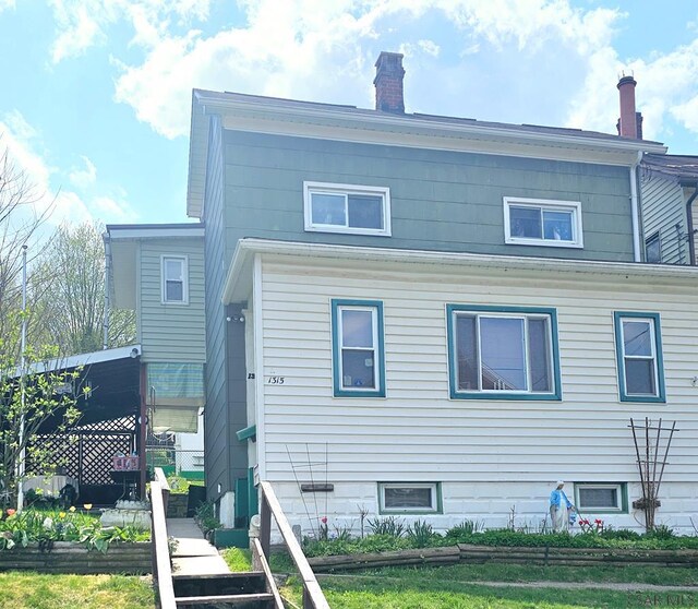 1315 Maryland Ave, Johnstown, PA 15906 - rear view of property featuring a vegetable garden and a chimney