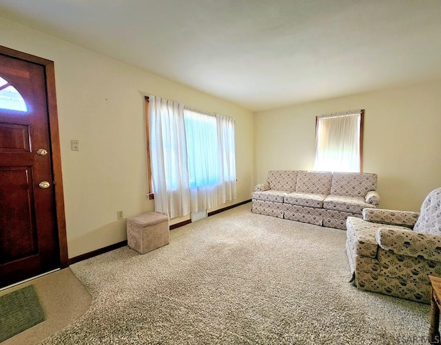 living room featuring visible vents, baseboards, and carpet