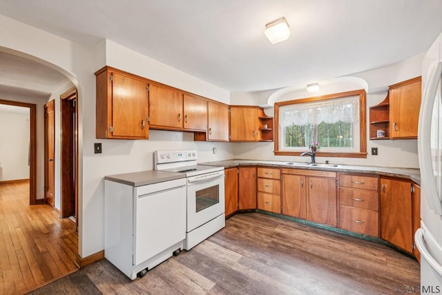 kitchen featuring white appliances, dark hardwood / wood-style floors, and sink