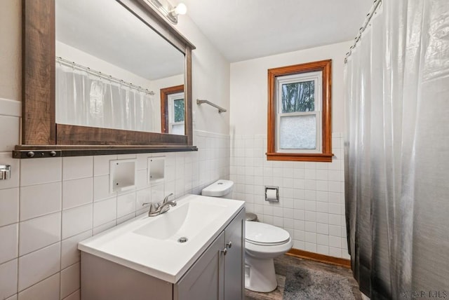 bathroom with vanity, tile walls, and toilet