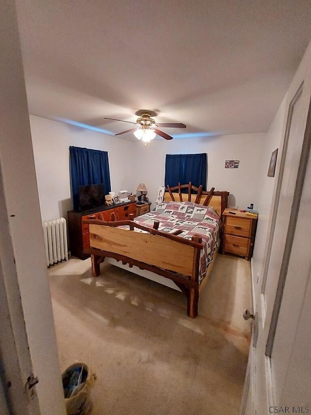 bedroom featuring ceiling fan, radiator heating unit, and light colored carpet