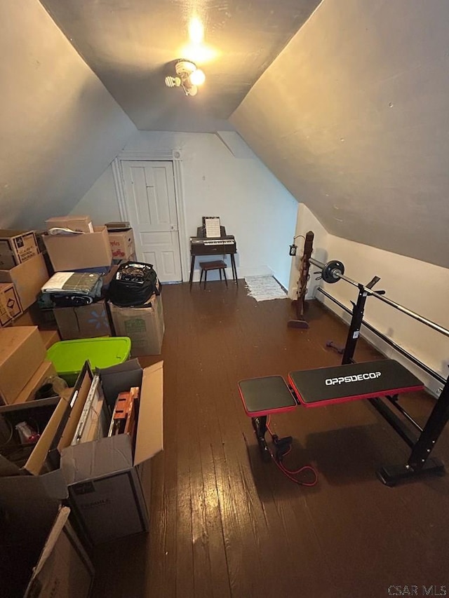 exercise room with lofted ceiling and hardwood / wood-style floors