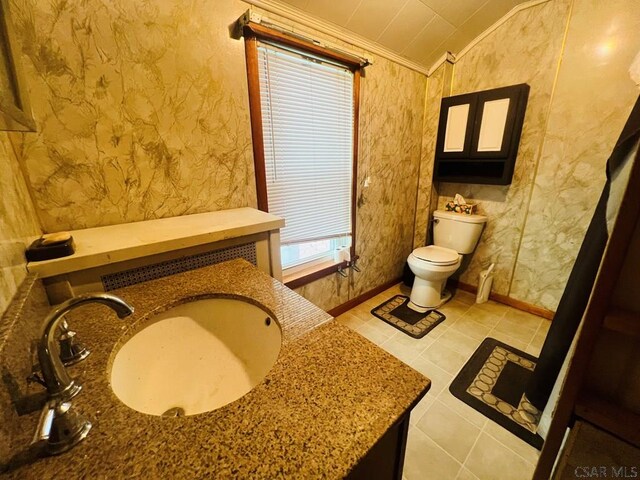 bathroom with lofted ceiling, sink, ornamental molding, tile patterned floors, and toilet