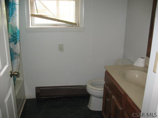 full bathroom with baseboard heating, vanity, toilet, and shower / bath combo