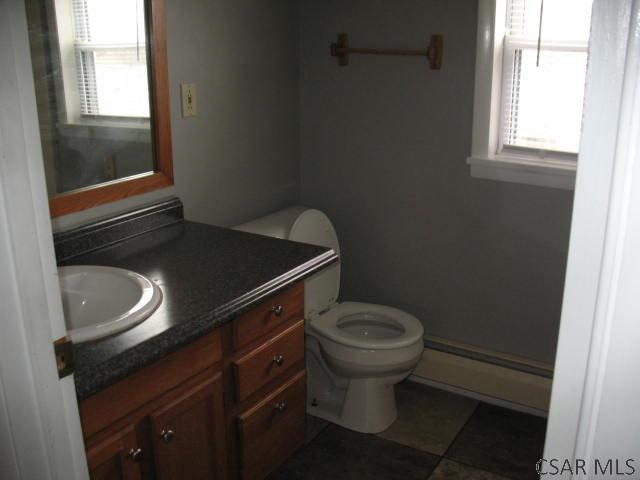 bathroom featuring baseboard heating, vanity, and toilet