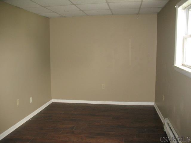 unfurnished room featuring a baseboard radiator and dark wood-type flooring