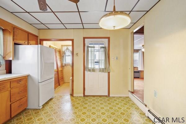 kitchen with hanging light fixtures, a paneled ceiling, baseboard heating, and white refrigerator