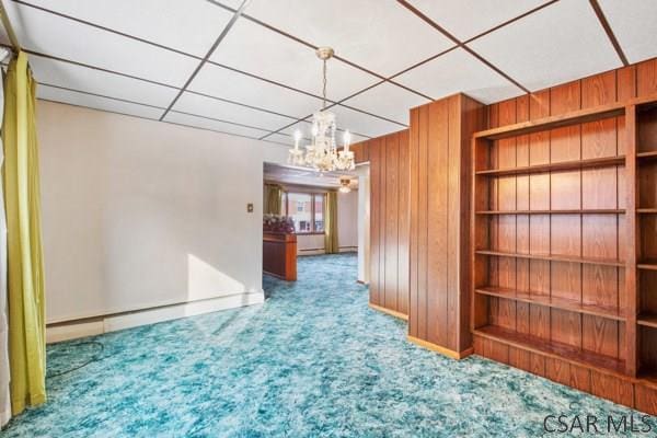 carpeted empty room with wood walls