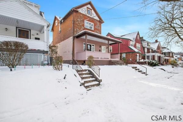 view of snow covered back of property